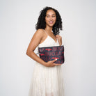 Model holding black clutch with red Dracula and bat lettering and silver bat charm