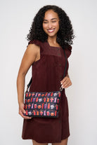 Model using extendible shoulder strap to wear Medium Convertible Clutch Shag Spooky Tiki Cocktail