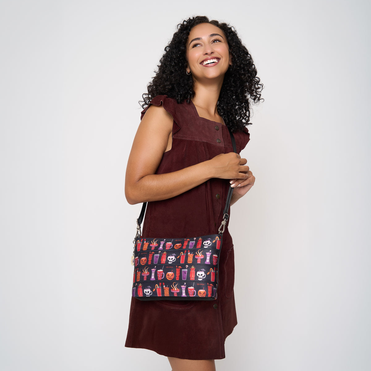Model using extendible shoulder strap to wear Medium Convertible Clutch Shag Spooky Tiki Cocktail