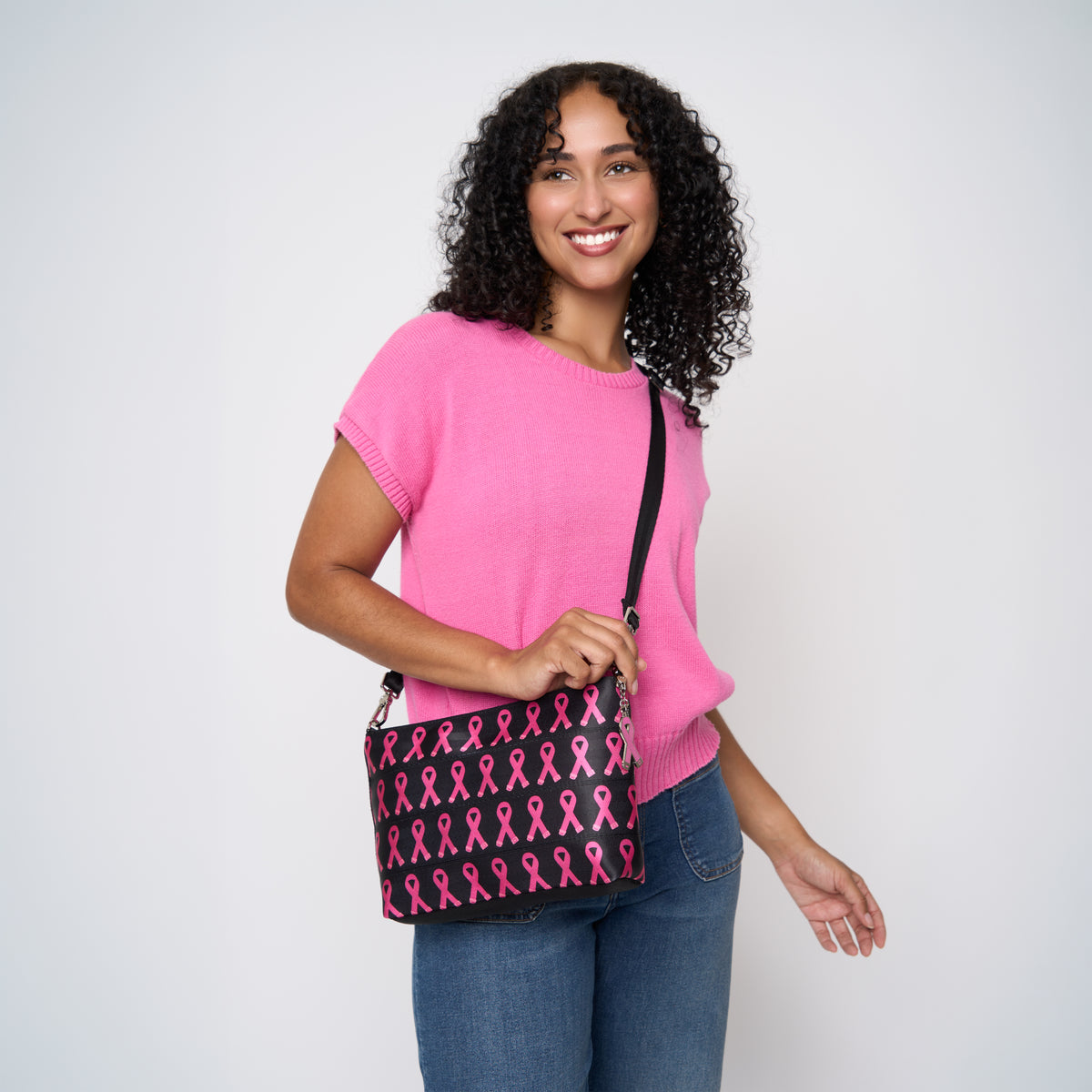 A model wearing The Pink Agenda Pink Ribbon Medium Convertible Clutch