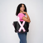 A model wearing The Pink Agenda Pink Ribbon Medium Streamline Tote