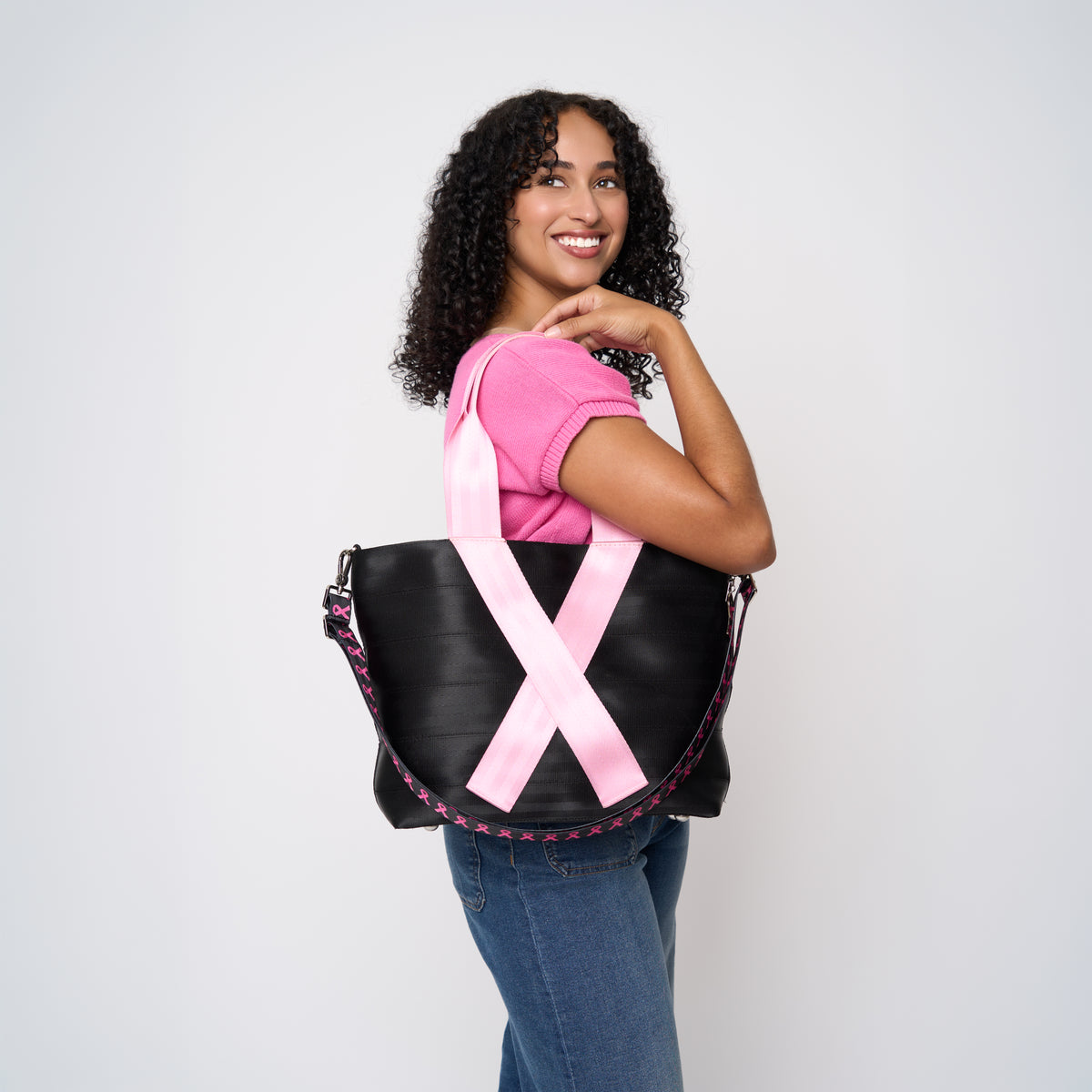 A model wearing The Pink Agenda Pink Ribbon Medium Streamline Tote
