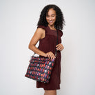 Model using extendable black strap to wear Medium Streamline Tote Shag Spooky Tiki Cocktail