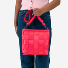 The Mini Messenger in Dragonfruit being held by a model