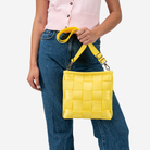 The Mini Messenger in Lemon being held by a model