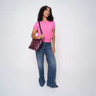 A model wearing The Pink Agenda Pink Ribbon Mini Streamline Tote