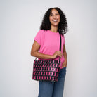 A model wearing The Pink Agenda Pink Ribbon Mini Streamline Tote