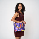 Model using extendable black strap to carry Mini Streamline Tote Shag Tiki Dance Party