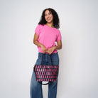 A model wearing The Pink Agenda Pink Ribbon Mini Streamline Tote