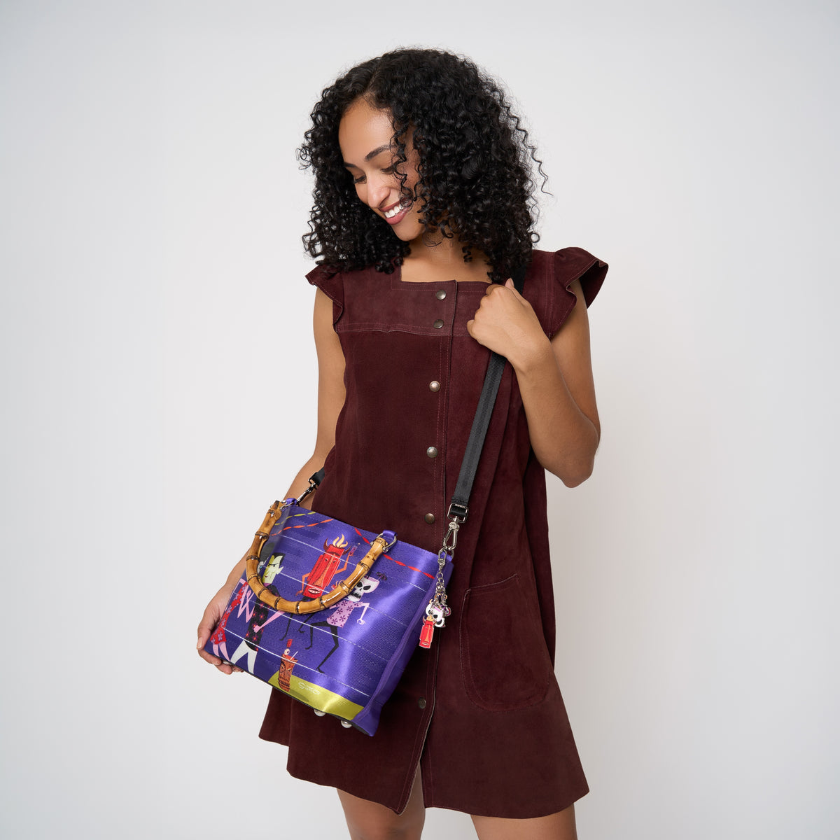 Model using extendable black strap to carry Mini Streamline Tote Shag Tiki Dance Party