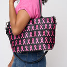 A model wearing The Pink Agenda Pink Ribbon Mini Streamline Tote