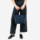 The Indigo Mini Streamline Tote being held in a models hands