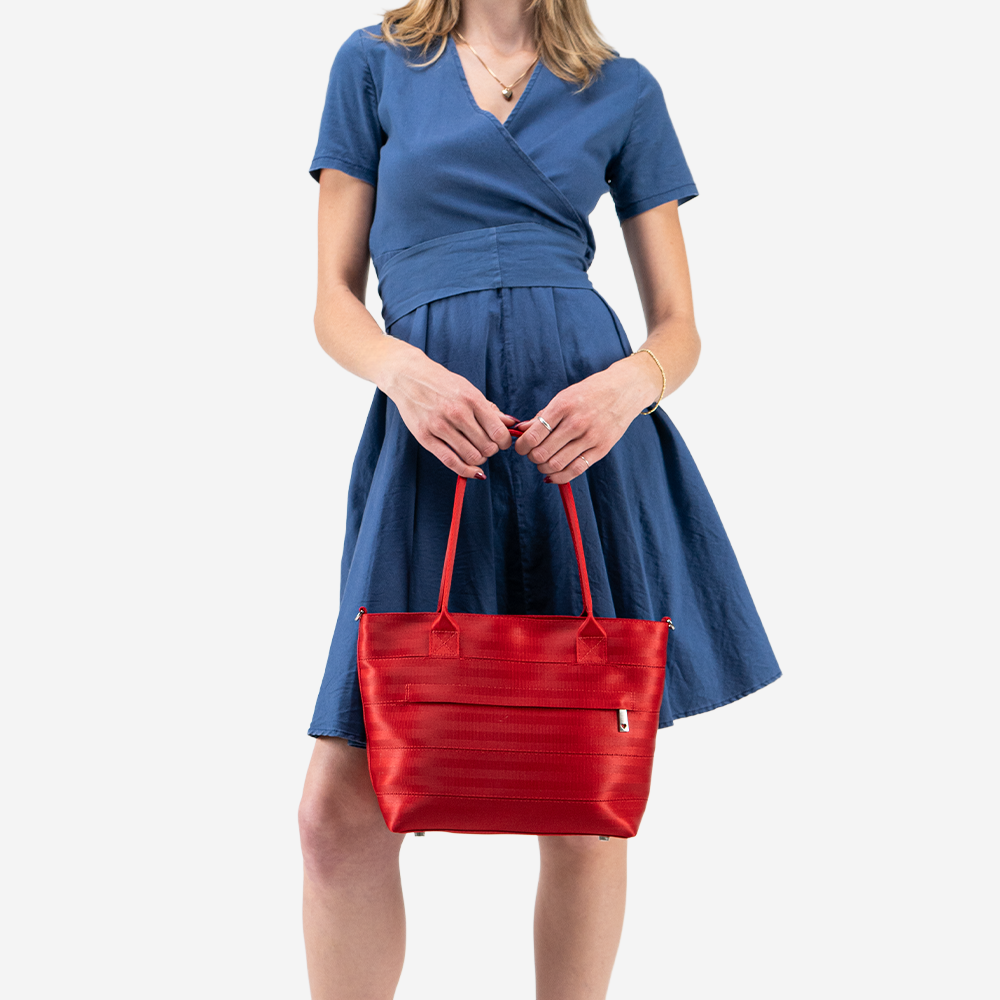 The Mini Streamline Tote in Scarlet being held in a models hands