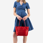 The Mini Streamline Tote in Scarlet being held in a models hands
