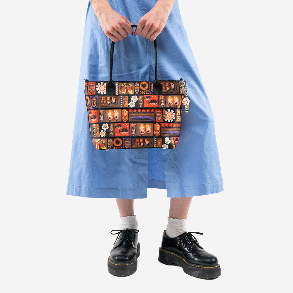 The Shag Tiki Tapa Mini Streamline Tote being held by a model