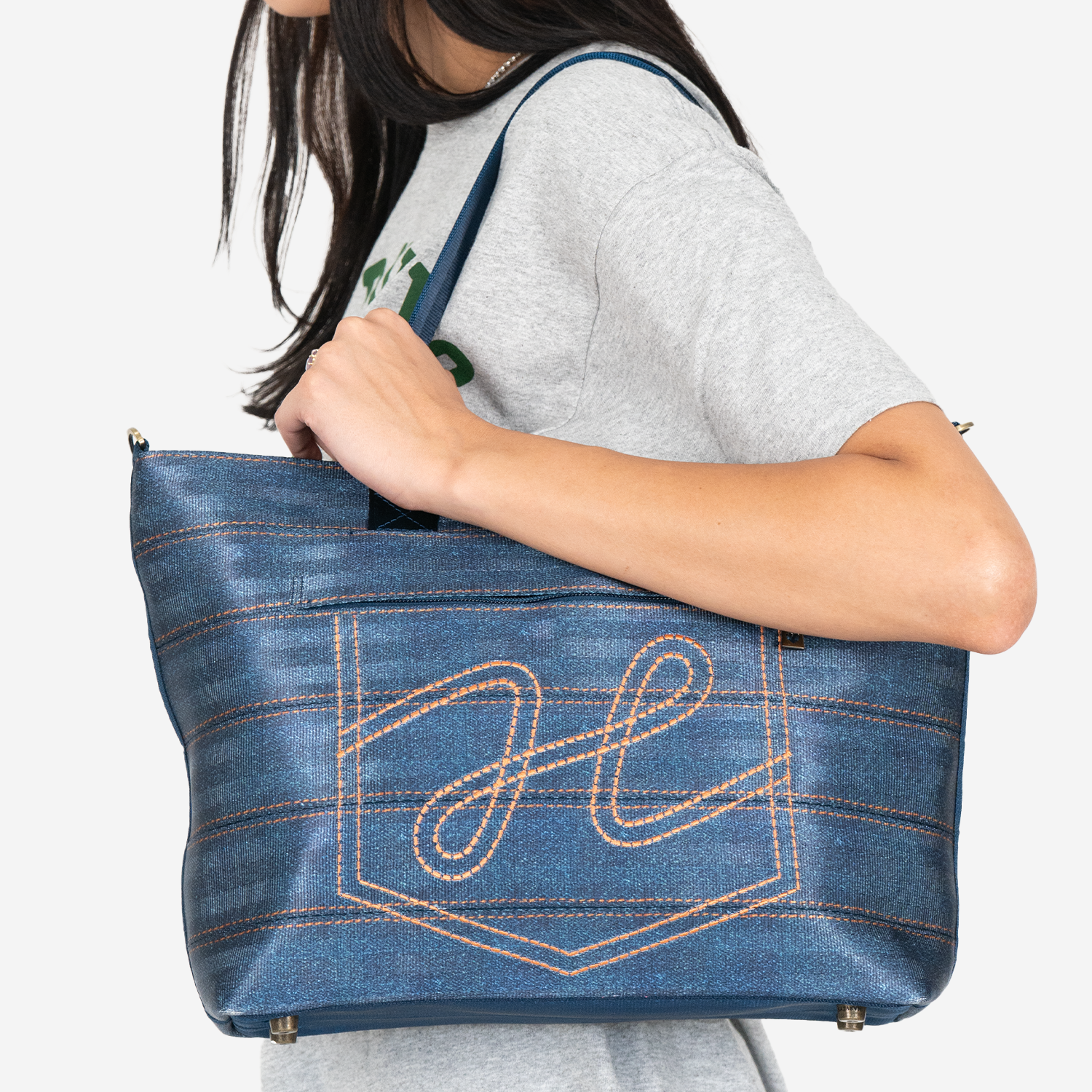 Shoulder view of a Medium Streamline Tote in Denim on a model