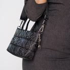 A model wearing a Black Widow Petite Tote