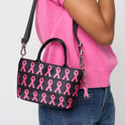 A model wearing The Pink Agenda Pink Ribbon Petite Tote