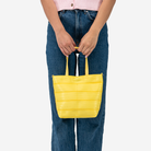 The Rosie Tote in Lemon being held by a model