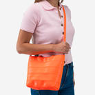 The Rosie Tote in Poppy being worn by a model