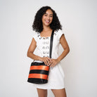 Model using adjustable strap to wear Rosie tote in Jack O'Lantern