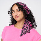 A model wearing The Pink Agenda Pink Ribbon Scarf