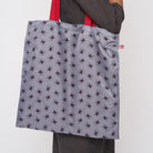 A model wearing a Black Widow Shopper Tote