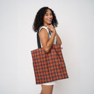 Model carrying shopper tote in Orange Tartan