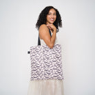 Model wearing shopper tote featuring bat design