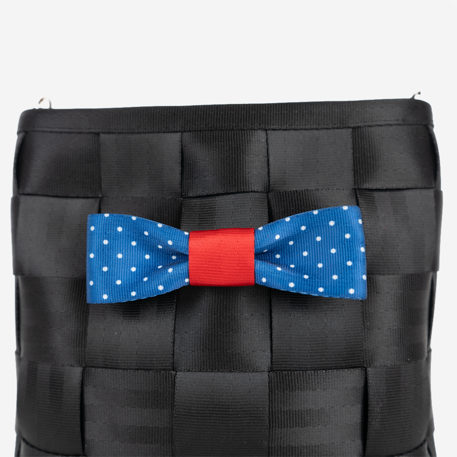 The Seatbelt Bow in Scarlet and Blue Dottie being used on a bag