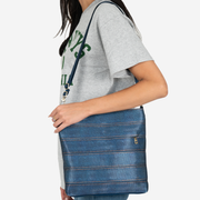 View of a Streamline Crossbody in Denim on a models shoulder