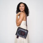 Model holding a crossbody book shaped bag with Dracula written on front