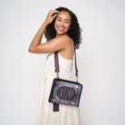 Model wearing black crossbody back shaped like book with Dracula strap