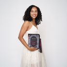 Model wearing black crossbody back shaped like book with Dracula strap