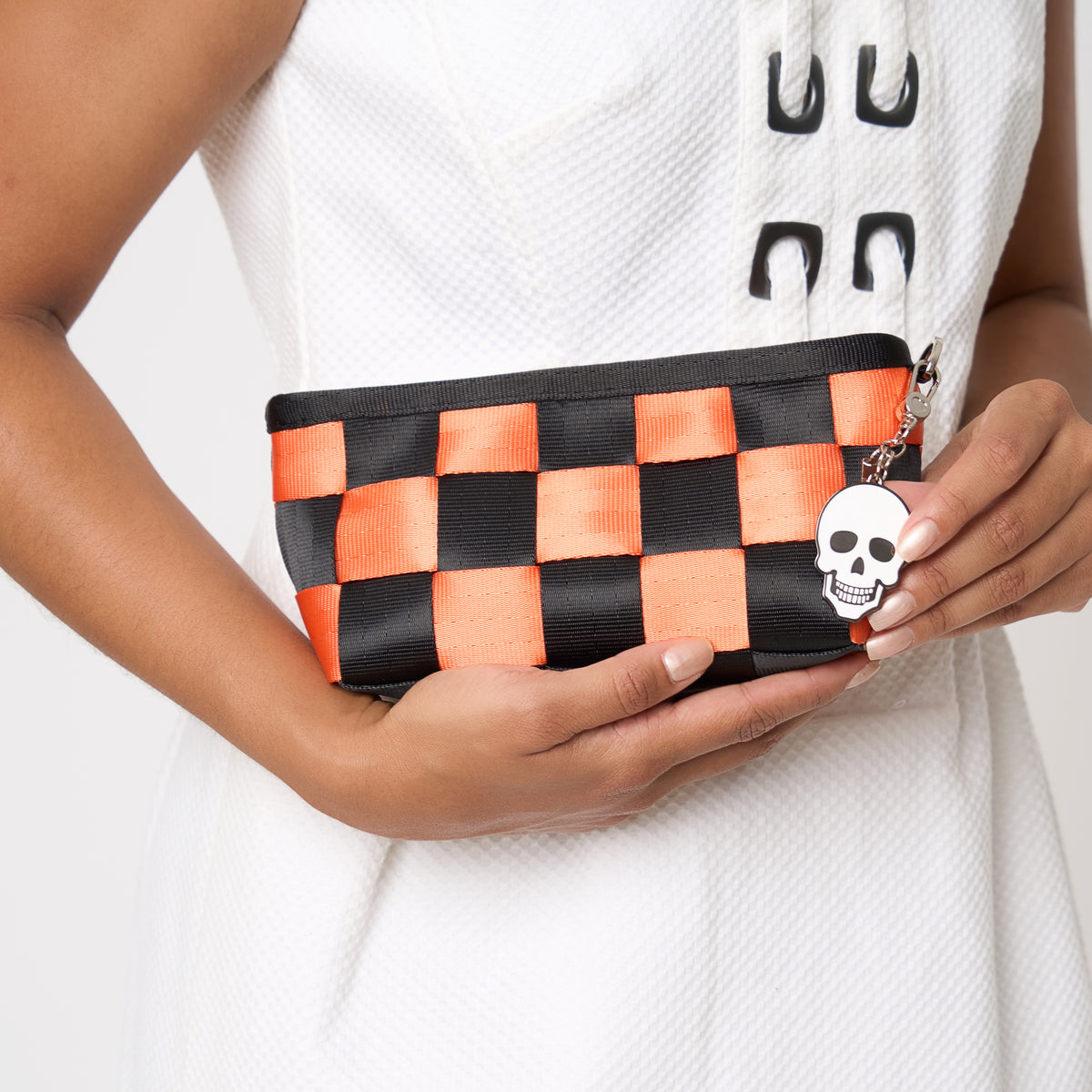 Model holding triangle makeup case in jack O' lantern