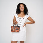 Model holding woven petite tote in orange tartan