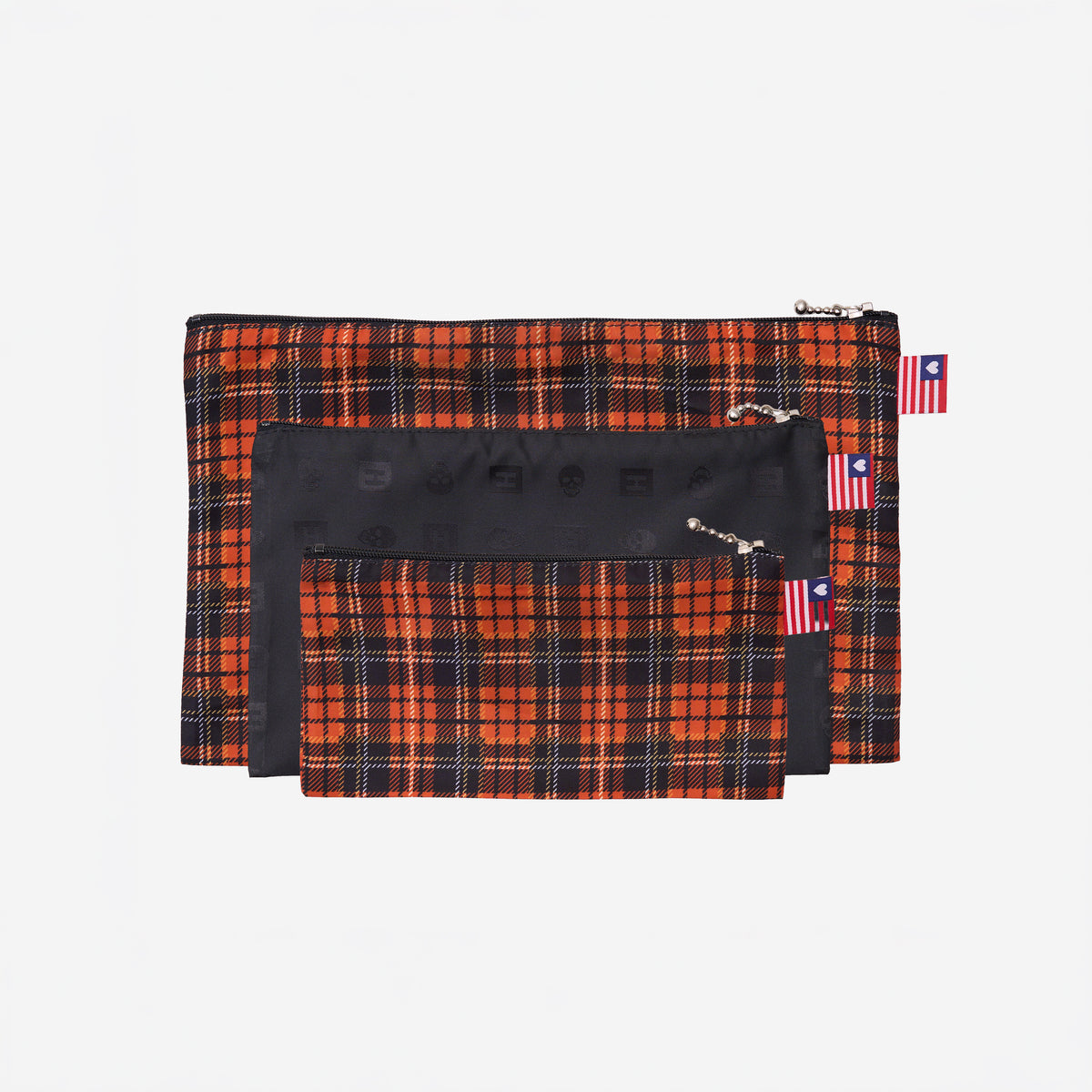View of 3 sizes of Zip N' Go Pouches in orange tartan & skulls
