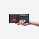 A Billfold in Indigo being held in a models hand