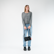 A Hip Pack in Black being held by a Model