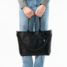 The Long Lola Click N Carry in Black being used on a bag by a model