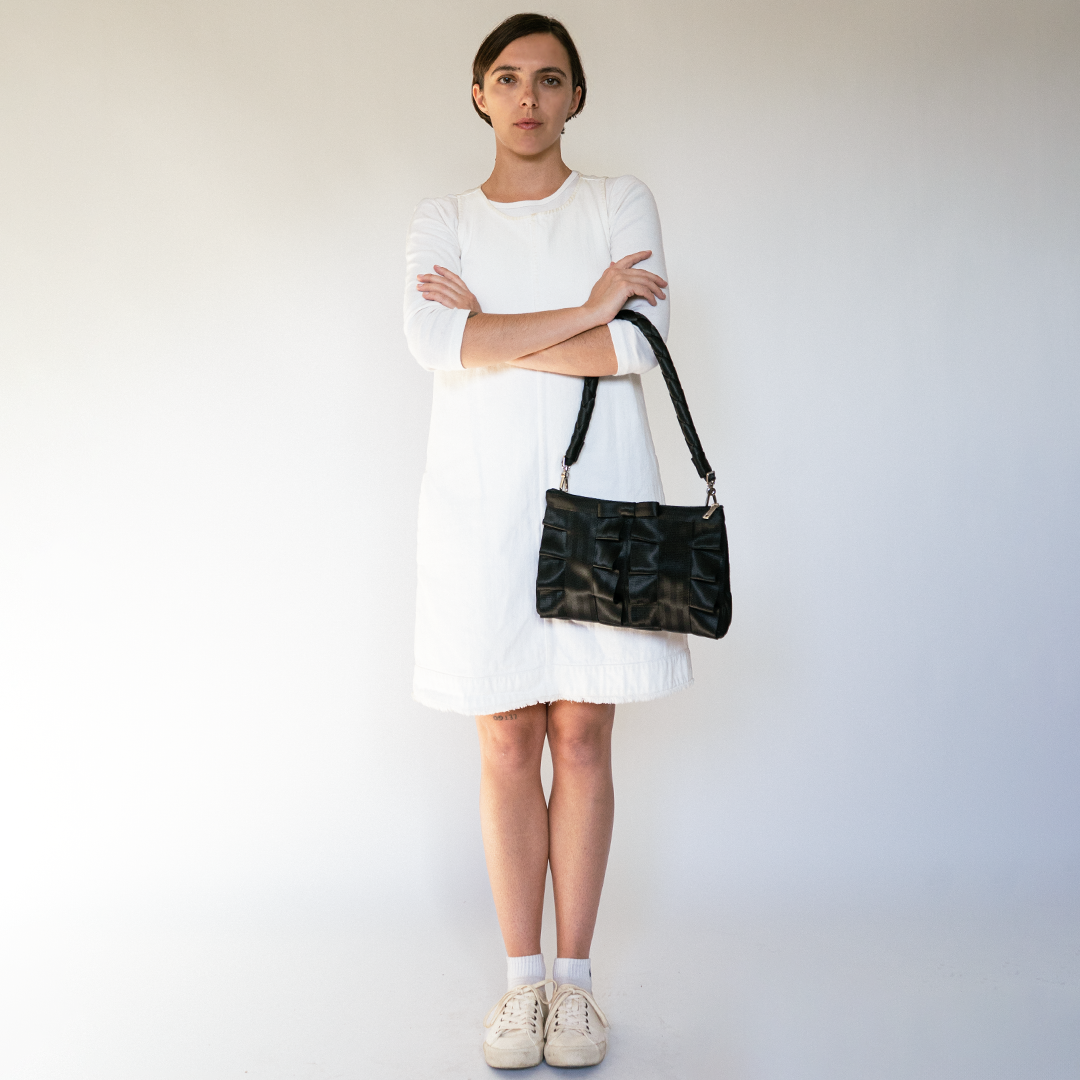 The Black Long Lola Click N Carry being used on a bag by a model