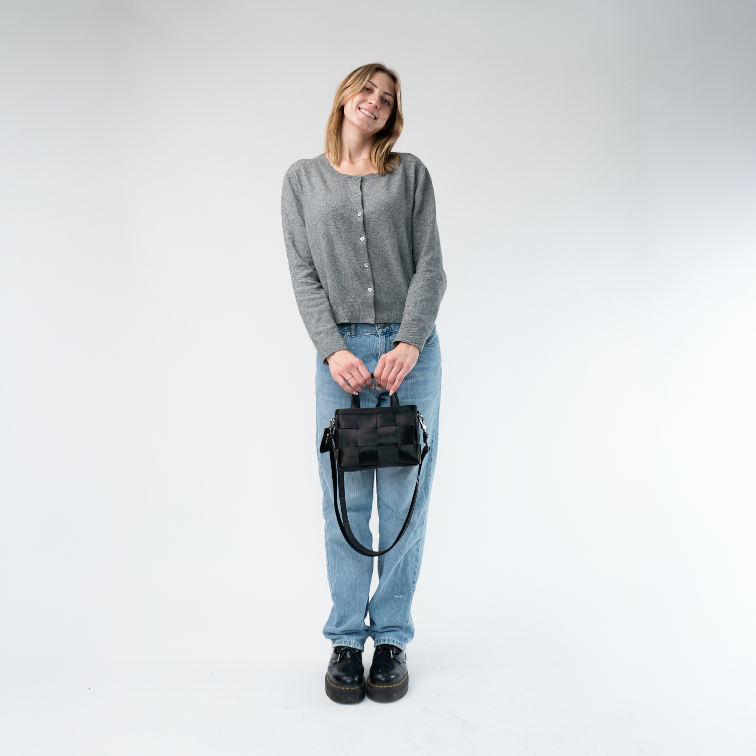 The Woven Petite Tote in Black in a model's hands