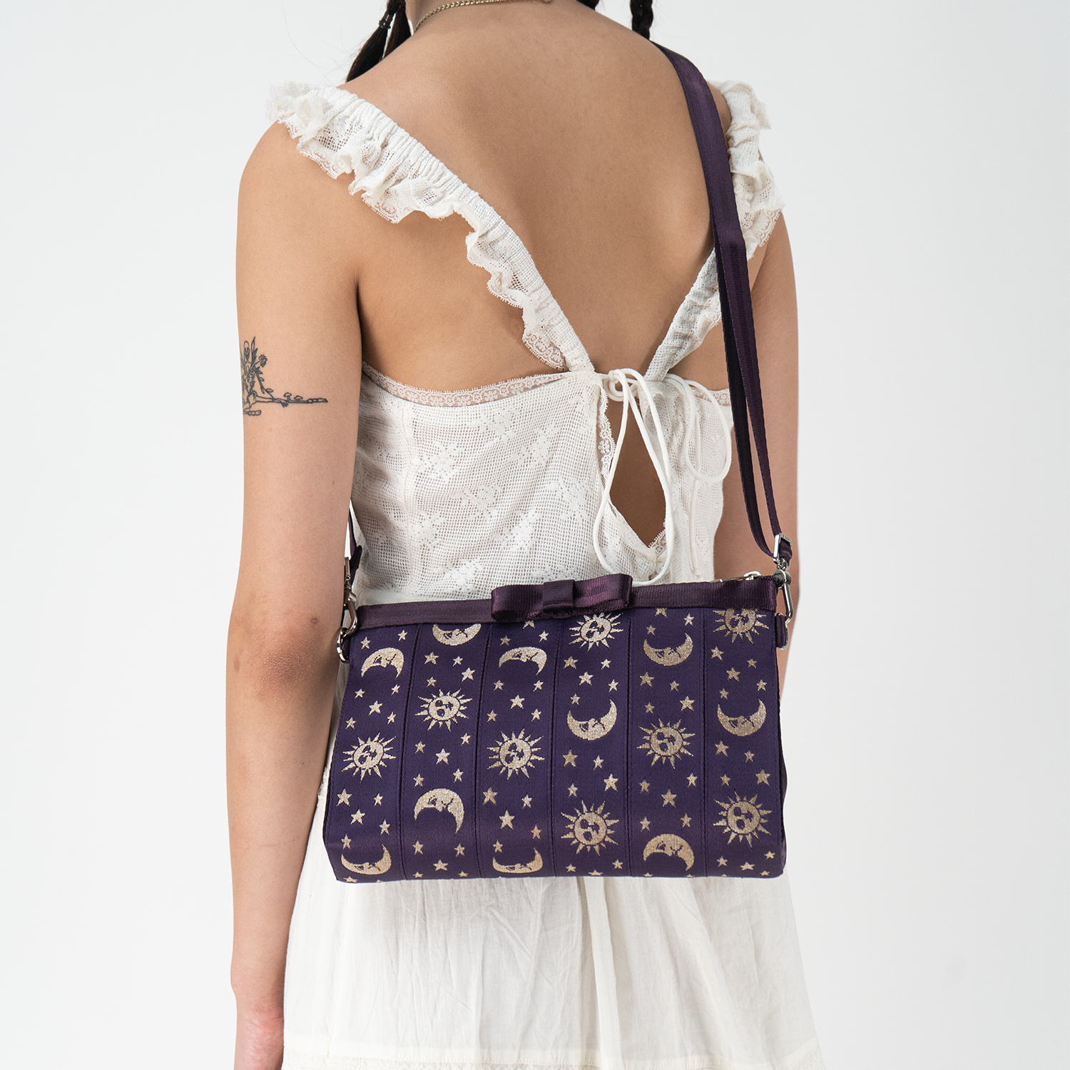 A Celestial Bow Clutch being worn by a model