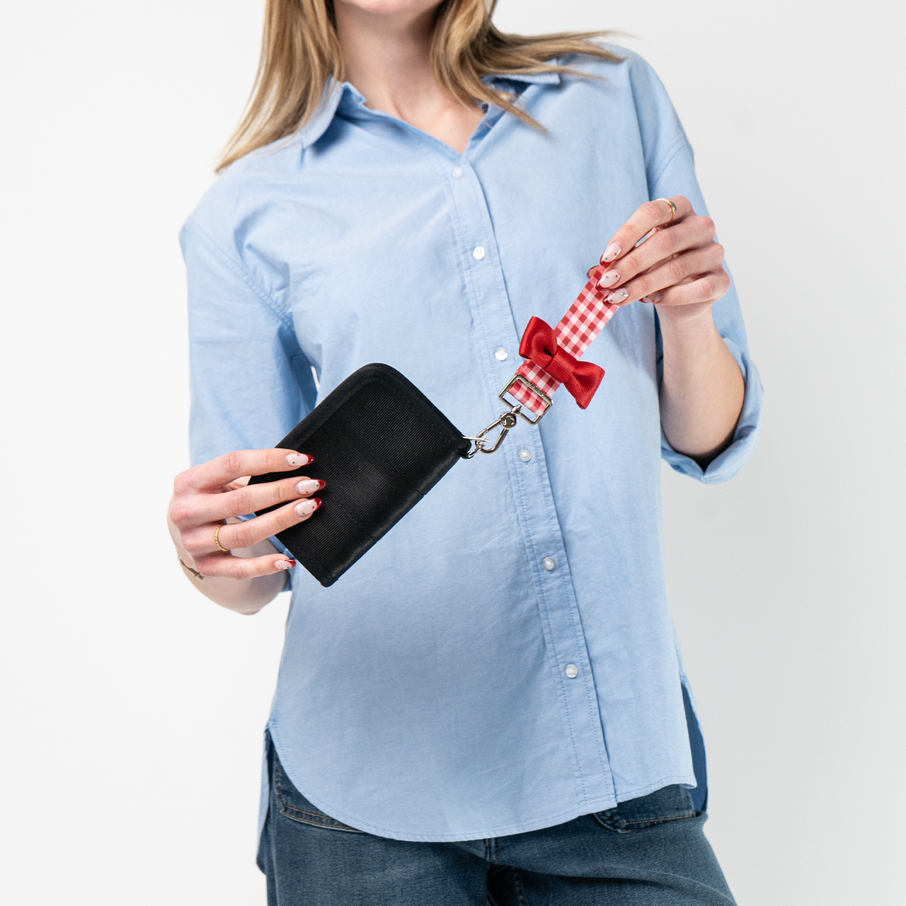 A Red Gingham Bow Keychain being used by a model