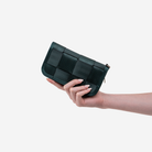The Classic Wallet in Nori being held by a model