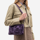 The Convertible Clutch in Blackberry being worn by a model