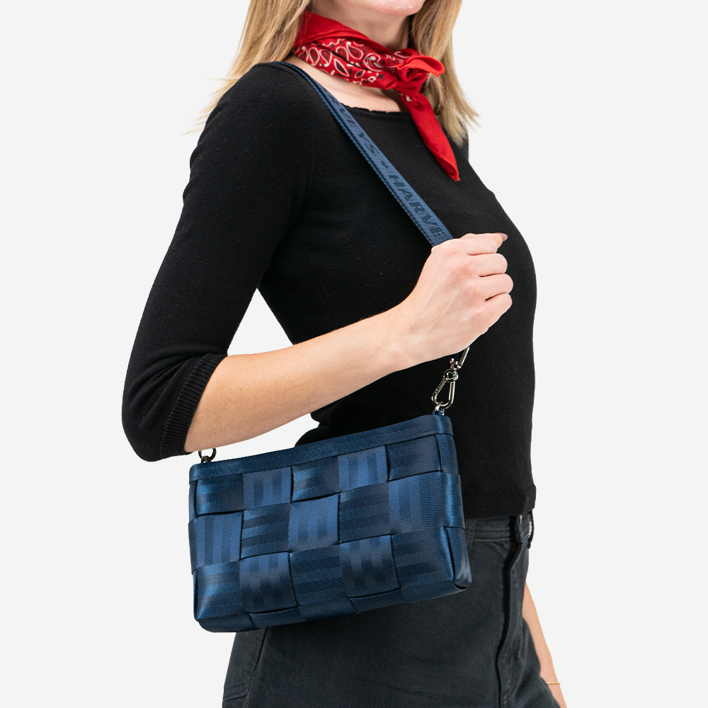 A Convertible Clutch in Indigo being worn by a model