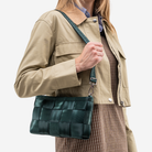 The Convertible Clutch in Nori being worn by a model