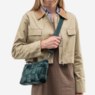 The Convertible Clutch in Nori being worn by a model