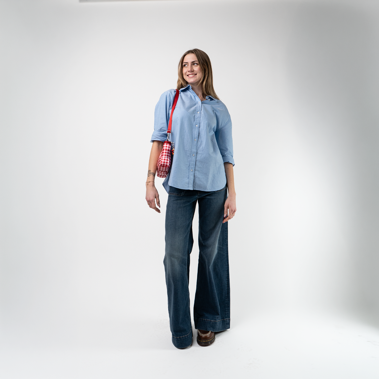 A Red Gingham Convertible Clutch being used by a model